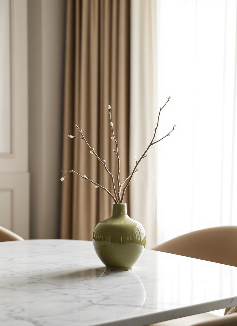 Olive vase with branches on marble dining table